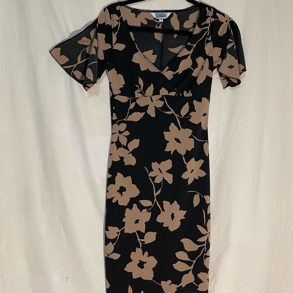 Flirty and fitted black dress with tan floral pattern fits small.